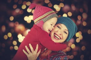 happy family mother and little daughter playing in the winter for Christmas
