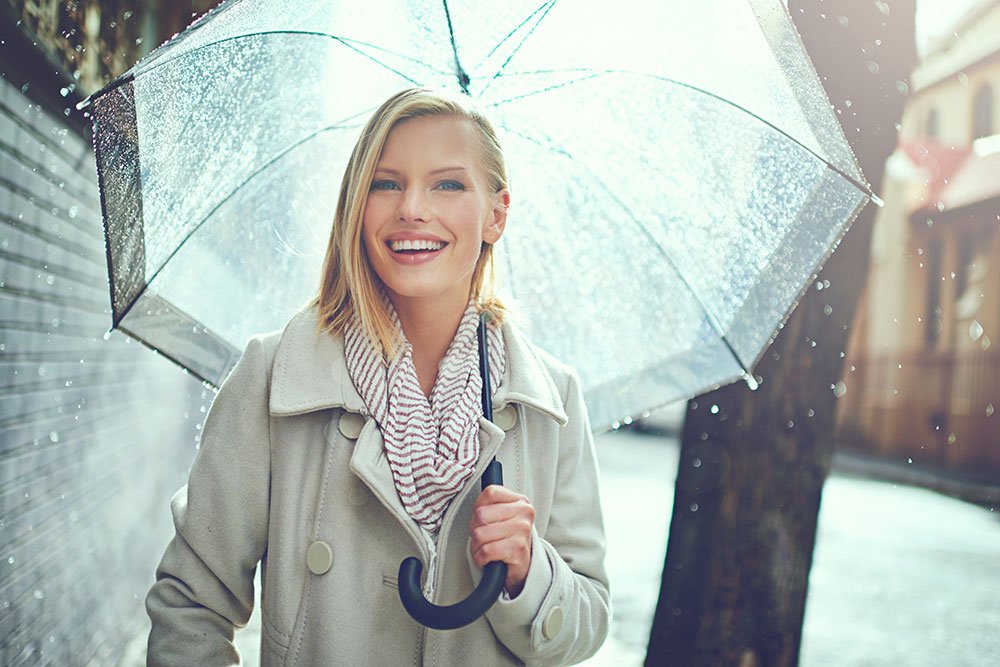 woman-smiling-holding-umbrella