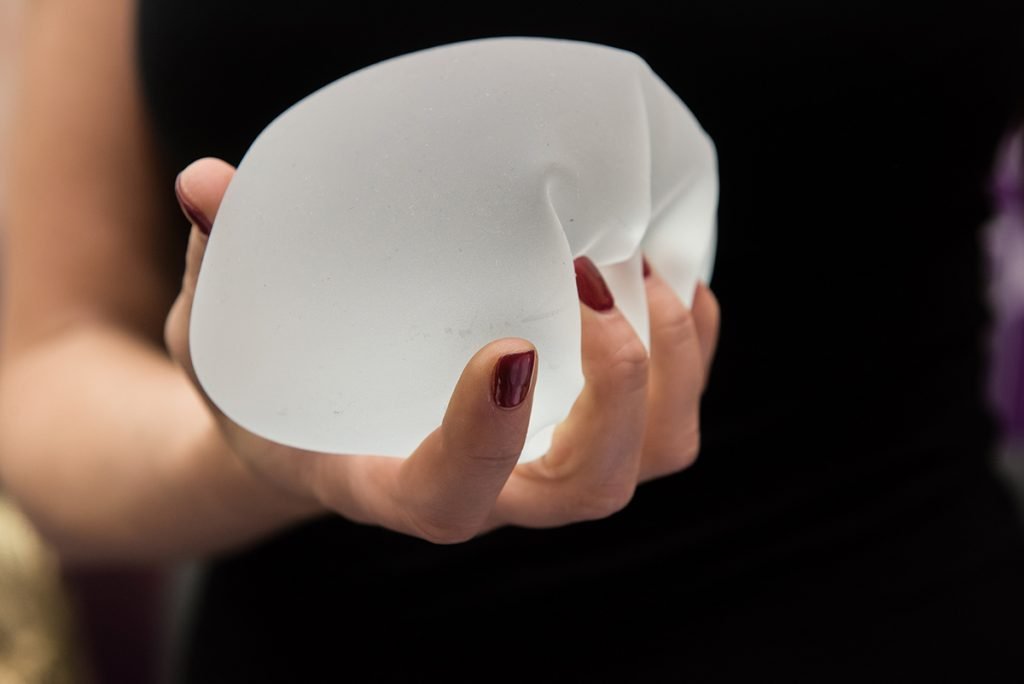 person holding textured breast implant