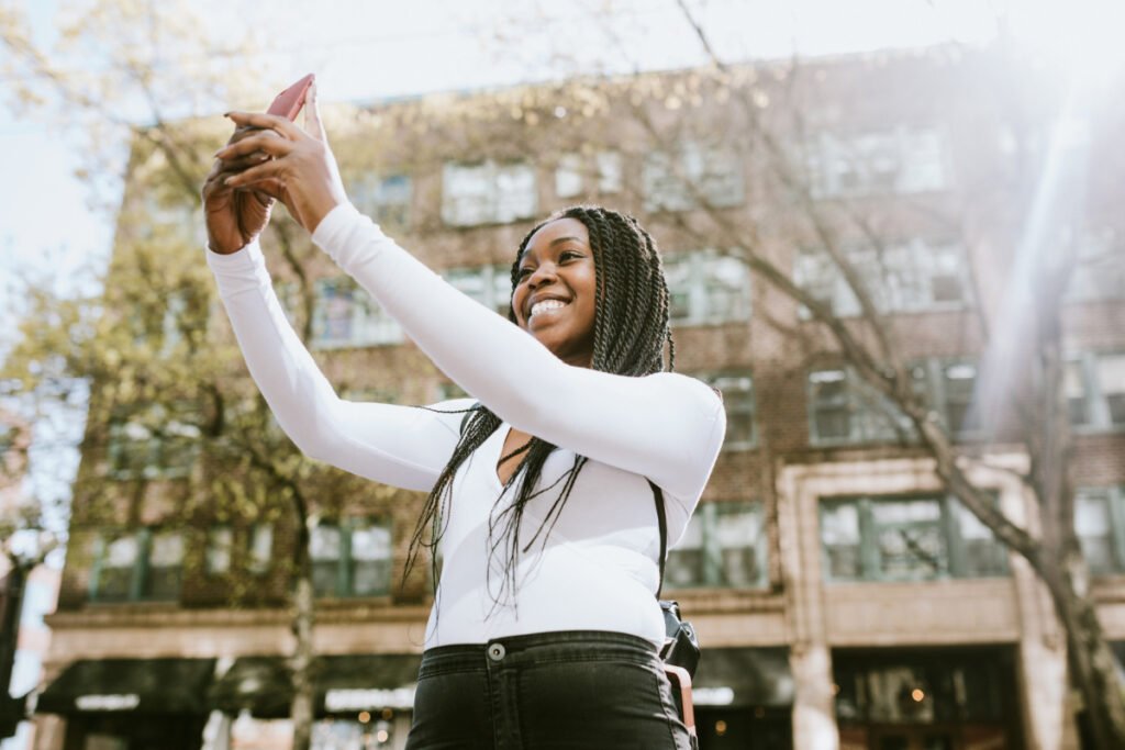 Young woman taking a selfie on her phone at a local photo spot