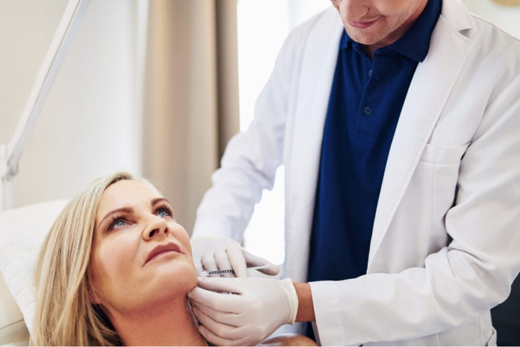 Cosmetic surgeon administering chin filler